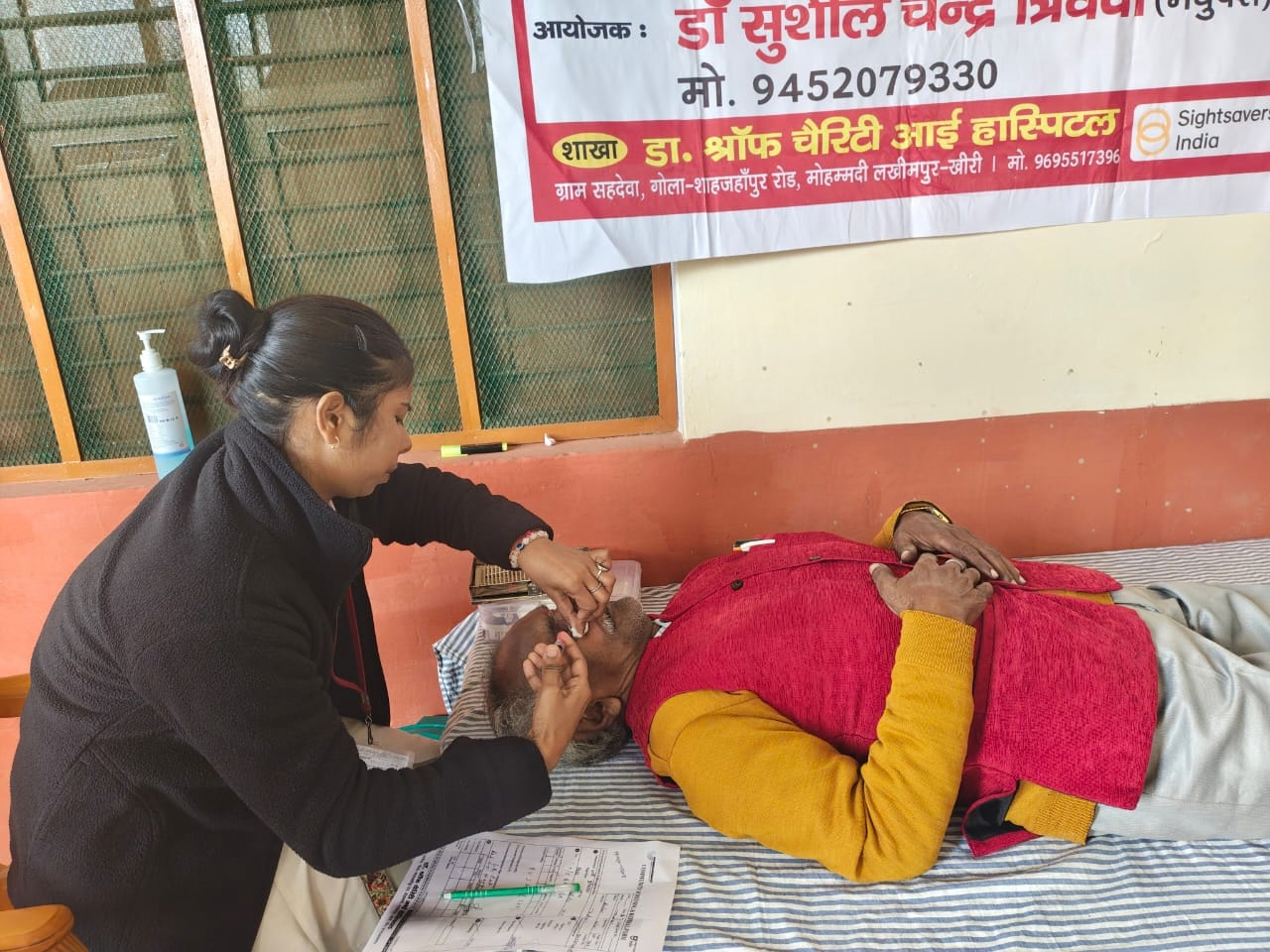 eye camp volunteer doing check up of a eye patient